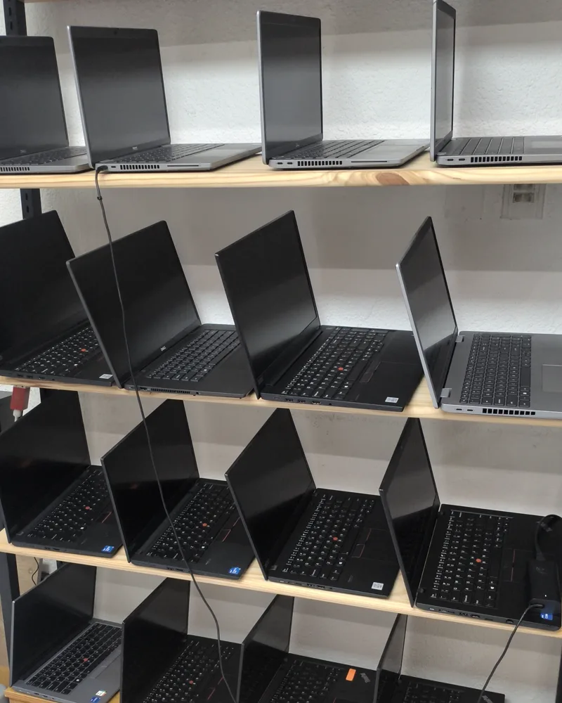Estantería con laptops seminuevas certificadas listas en el local de Sysland, Quito