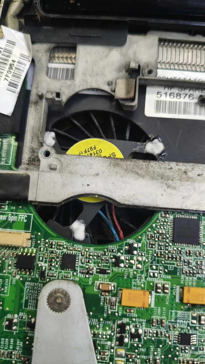 Interior de una laptop abierta: ventilador, placa y limpieza con pasta térmica